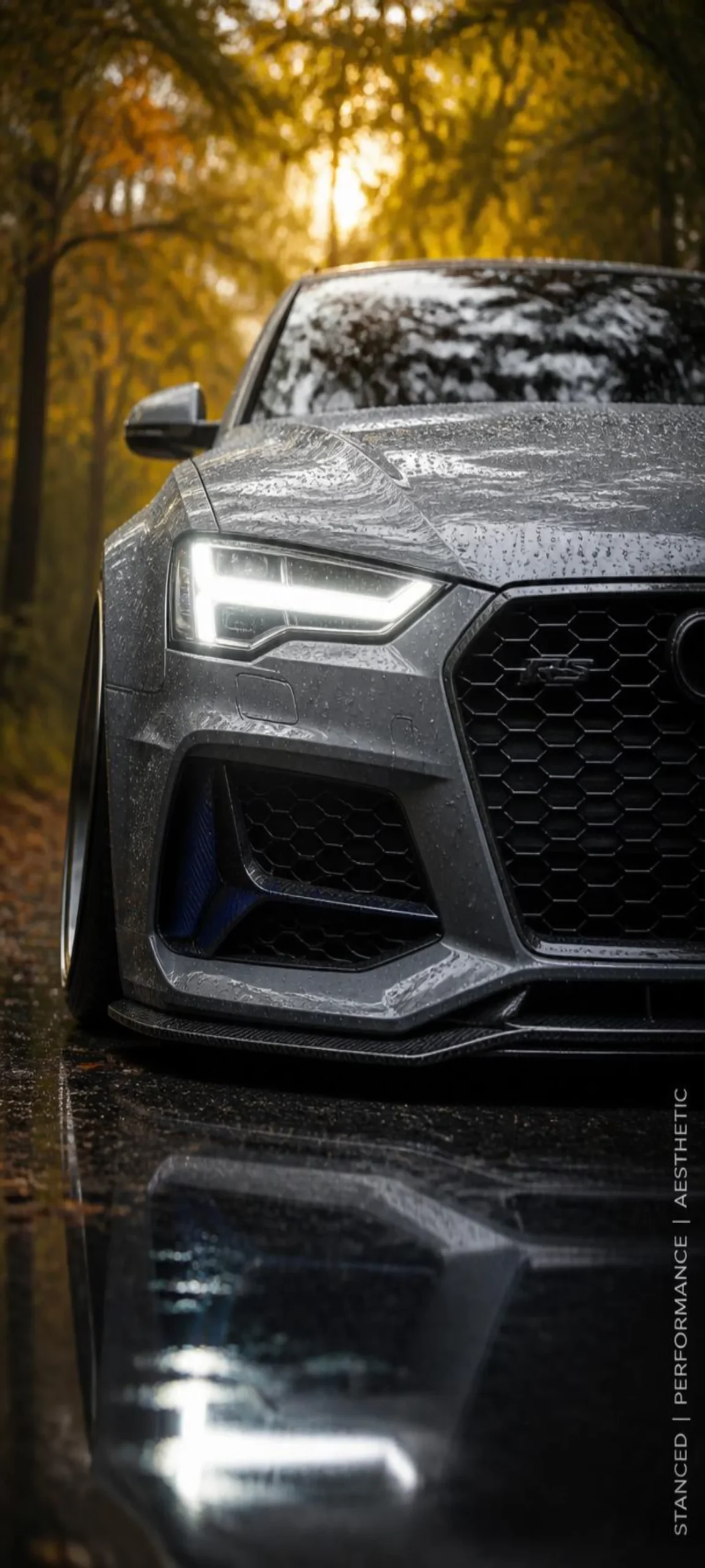 Lade dieses extrem scharfe Audi RS Smartphone-Wallpaper kostenlos herunter. Nardograuer Lack mit Regentropfen und herbstlicher Spiegelung – ideal fürs Handy.