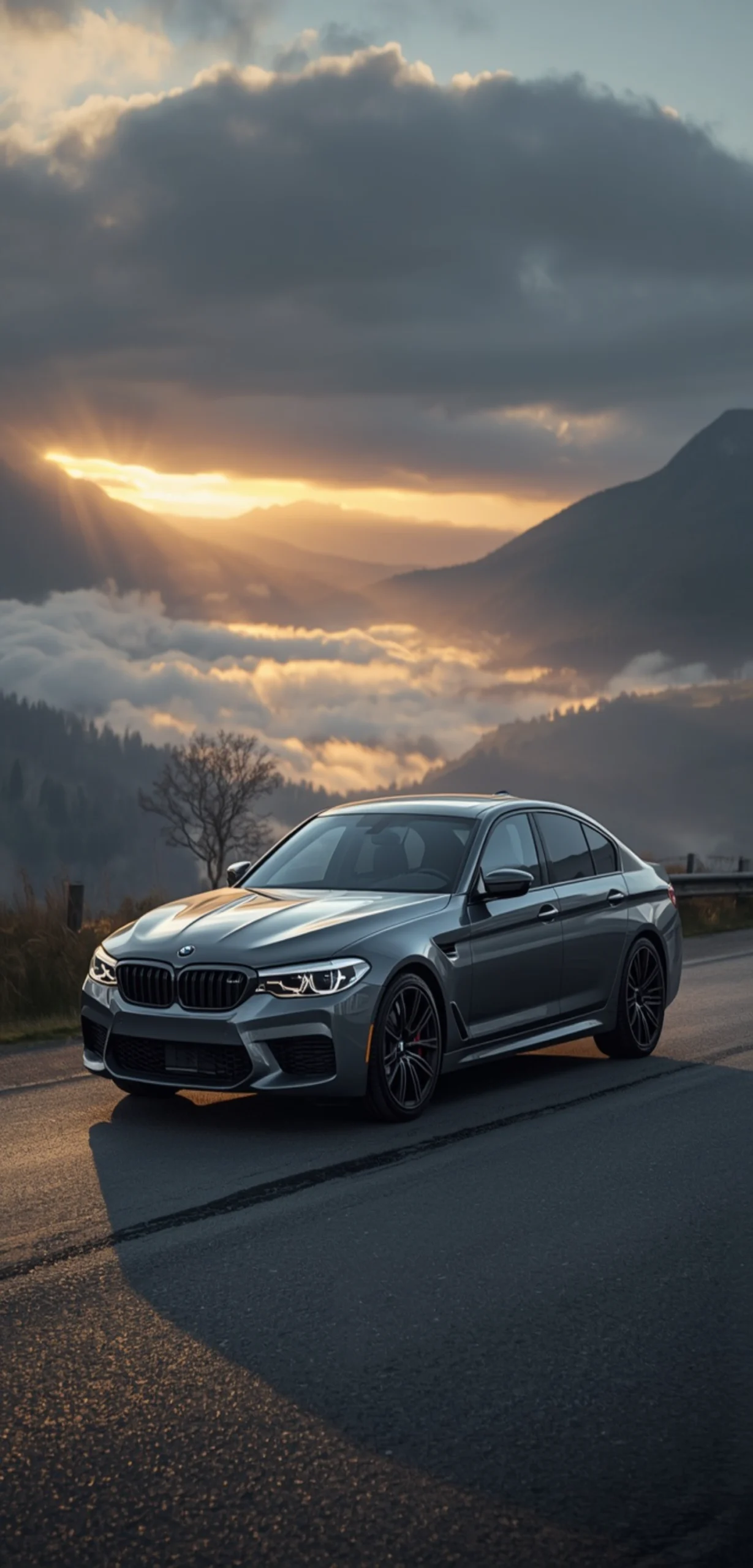 Grauer BMW M5 F90 auf einer Bergstraße bei Sonnenaufgang mit Nebel, Wolkenmeer und dramatischer Alpenkulisse als 4K Handy-Hintergrund.