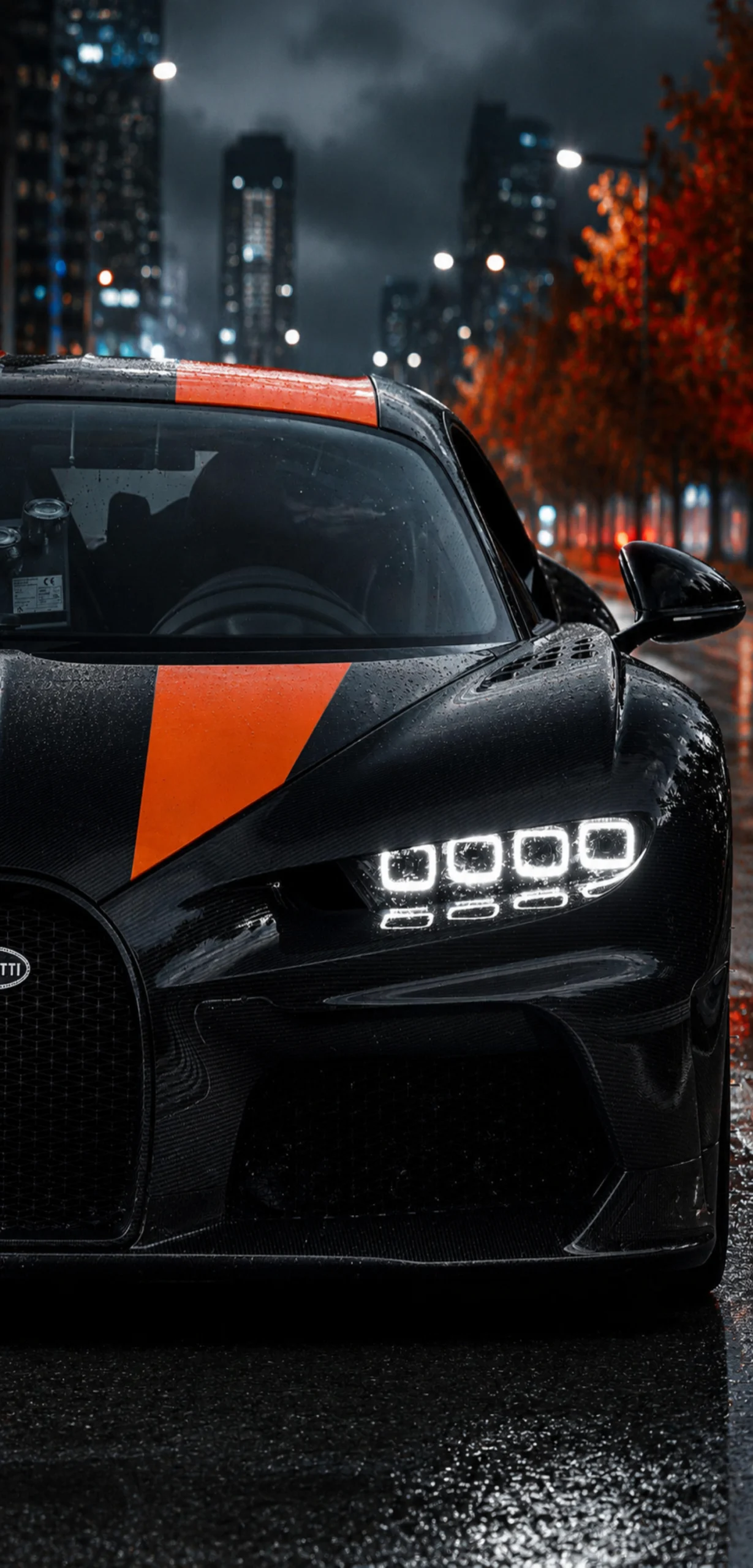 Schwarzer Bugatti Hypercar mit orangen Akzenten in Nahaufnahme vor nächtlicher Skyline